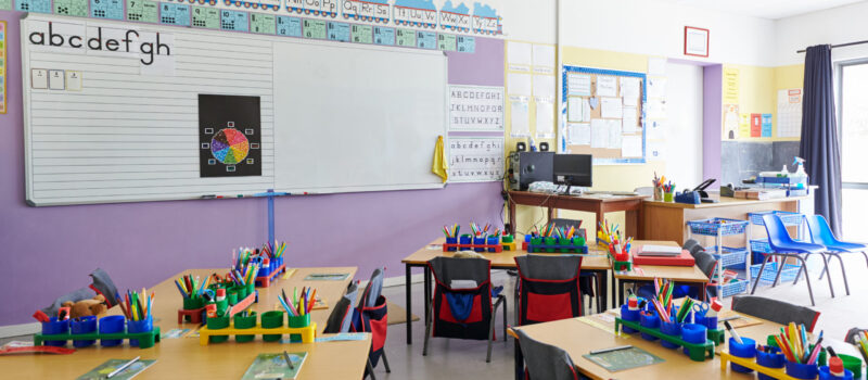 Empty Classroom In Elementary School With Whiteboard And Desks